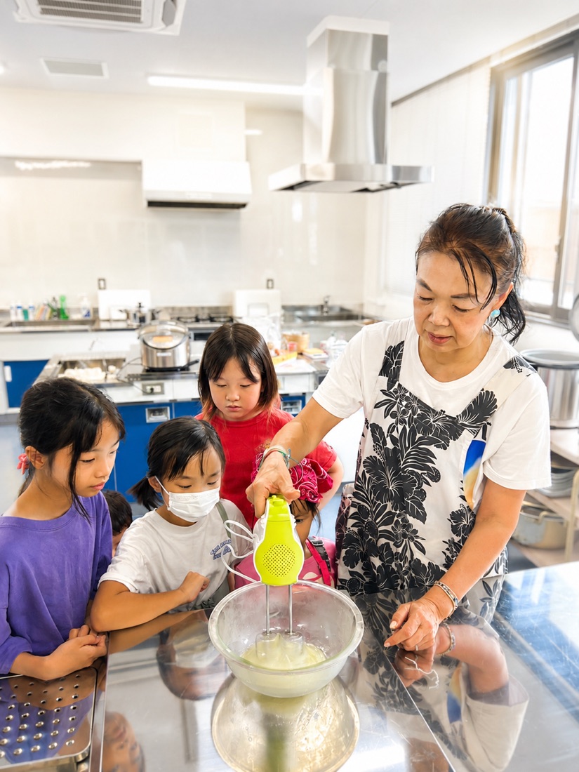 ハンドミキサーで生地を混ぜる子どもたちと見守るひろちゃん